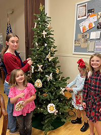 Image of Blaize, Lulu, Reese and Rilynn decorating the CHrismon tree